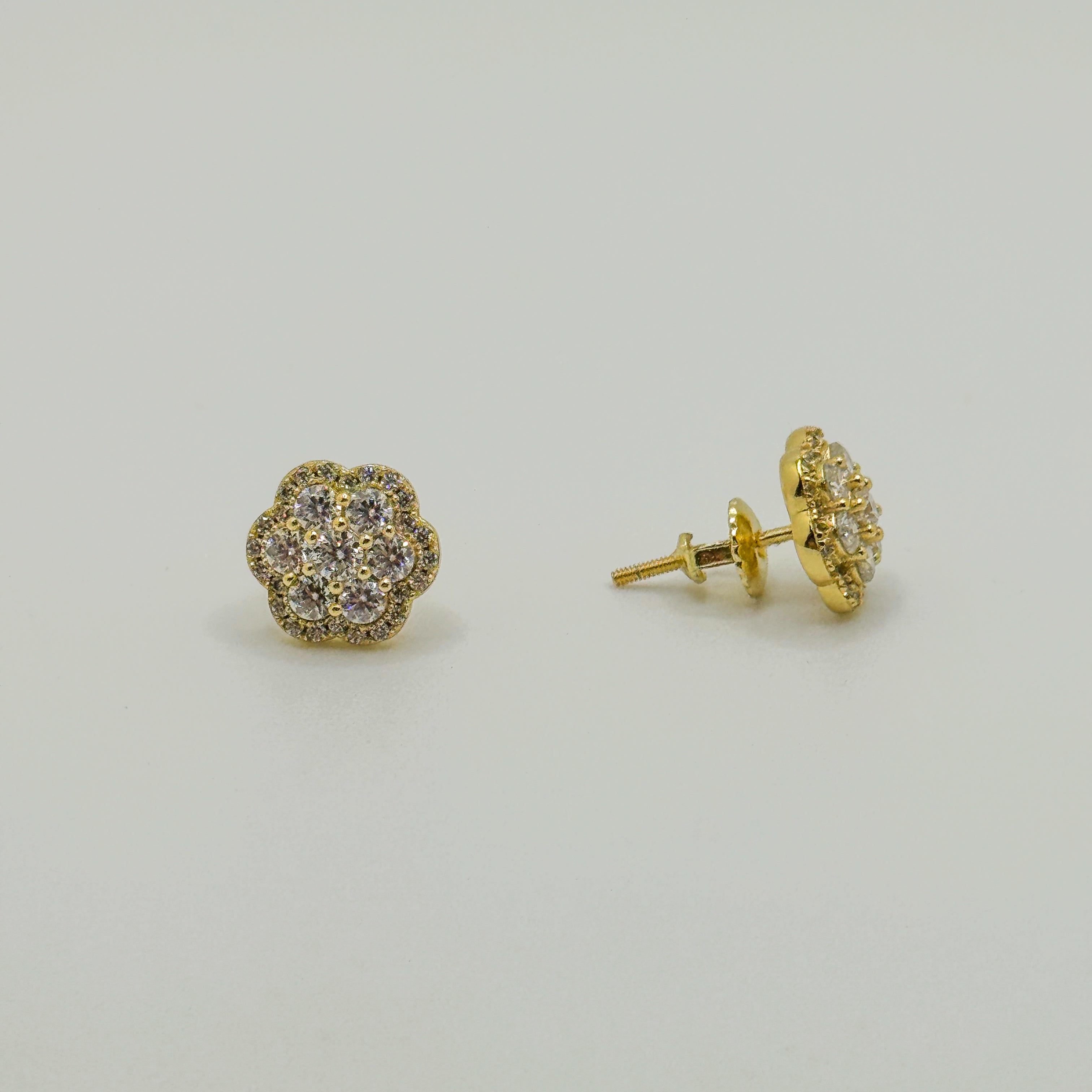 A pair of gold stud earrings with a small cluster of clear pavé stones, shown on a plain light gray background. One earring is facing forward, and the other is turned to show the post and backing.