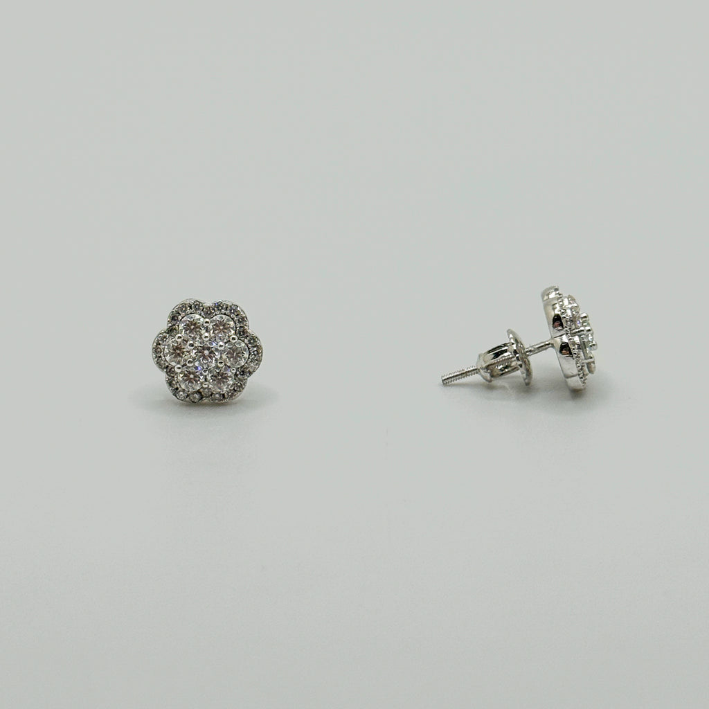 A pair of silver stud earrings with round floral clusters of small clear stones, shown on a plain light gray background. One earring is facing forward and the other is turned to show the post and backing.
