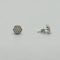 A pair of silver stud earrings with round floral clusters of small clear stones, shown on a plain light gray background. One earring is facing forward and the other is turned to show the post and backing.