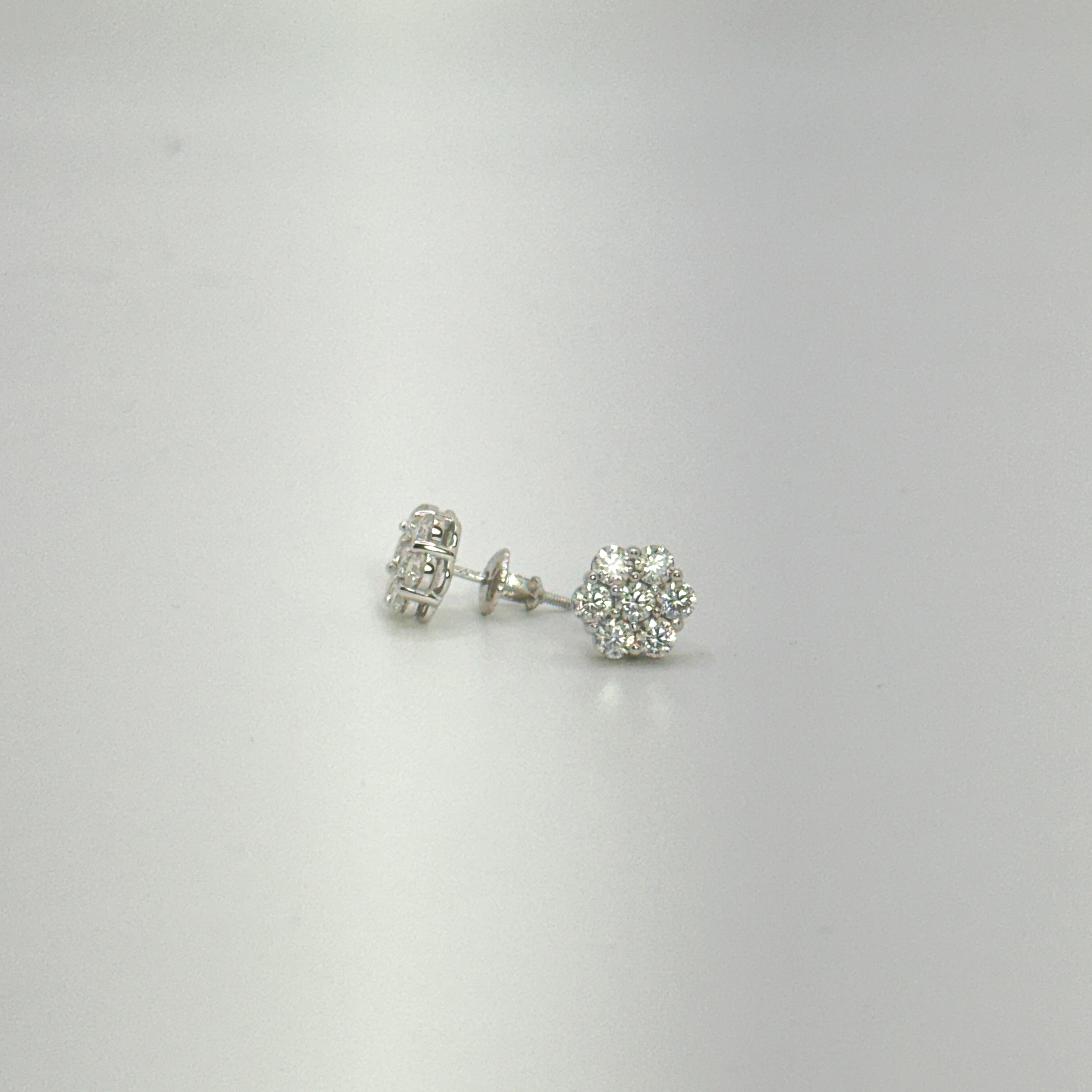 A pair of silver stud earrings with clear gemstones, displayed on a plain light gray background.